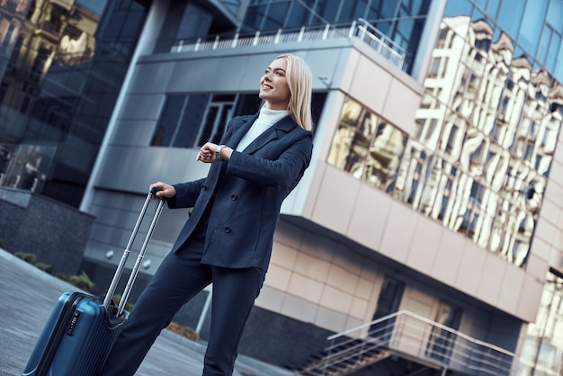 写真 スーツケースを持って歩く若い女性