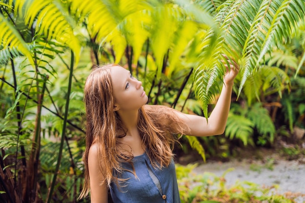 A young woman walks among the ferns