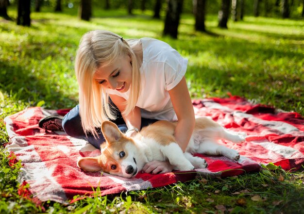 Photo a young woman walks her dog in a summer park