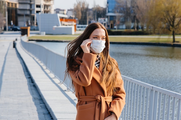 A young woman walks in a mask during the pandemic