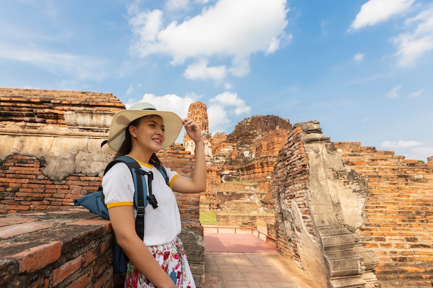 A young woman walks in the old temple in Phra Nakhon Si Ayutthaya, Thailand on a relaxing day.