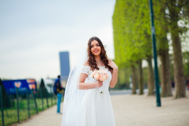 Young woman walks in white lace dress, high-heeled shoes, Paris,