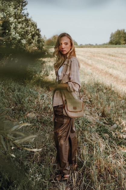 A young woman walks with a retro camera and takes pictures of nature