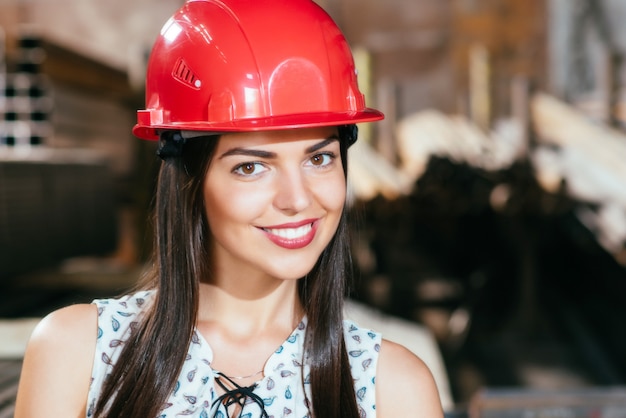 Giovane donna in un magazzino con un casco di sicurezza