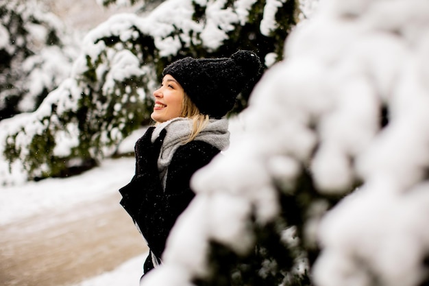 Giovane donna in vestiti caldi che gode nella neve