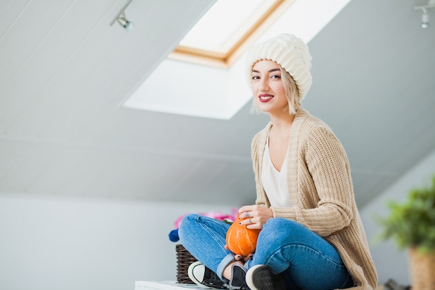 Young woman in warm hand knitted hat at home