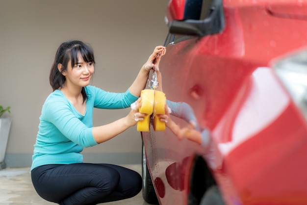 Young woman washing a car