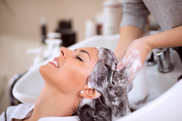 Young woman washing hair in salon