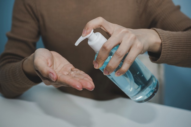 Foto mano di lavaggio della giovane donna con il gel dell'alcool