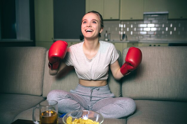 Молодая женщина смотреть бокс по телевизору ночью