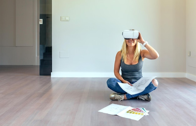 Молодая женщина наблюдает за украшением своего дома в очках виртуальной реальности