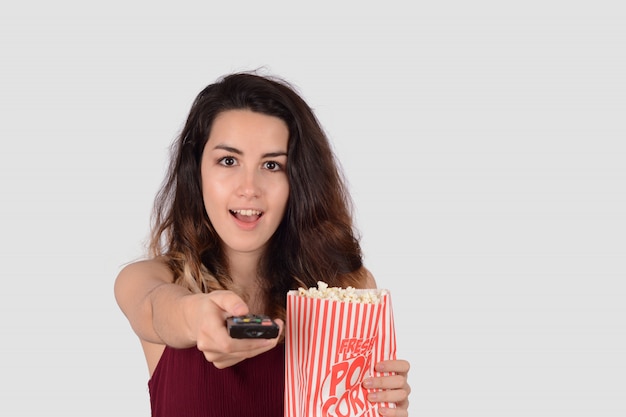 Young woman watching a movie and eating popcorn.