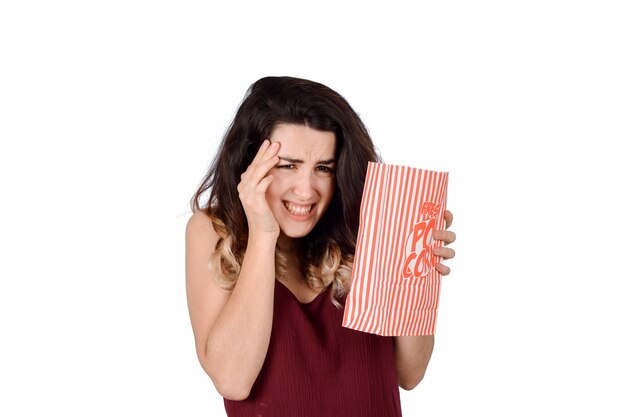 Foto giovane donna guardando un film spaventoso e mangiando popcorn.