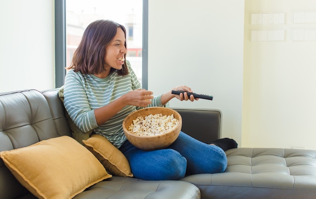 家でテレビを見ている若い女性