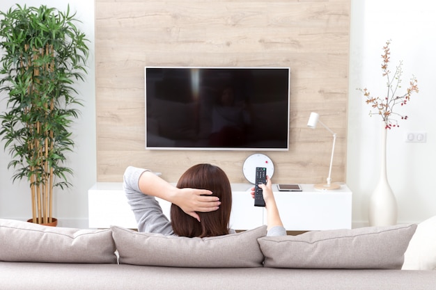 Photo young woman watching tv in the room