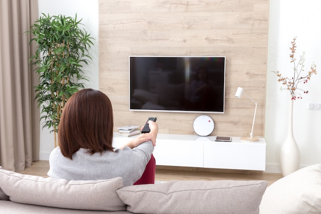 部屋でテレビを見ている若い女性