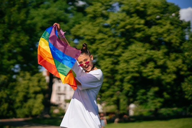 공원에서 LGBT 프라이드 깃발을 흔드는 젊은 여성