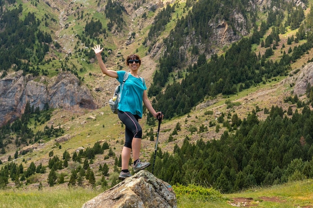 여름에 피레네 산맥 Alto Gallego Huesca의 산에서 손을 흔드는 젊은 여성