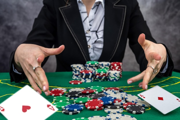 Молодая женщина в черном костюме играет в покер в победителе казино