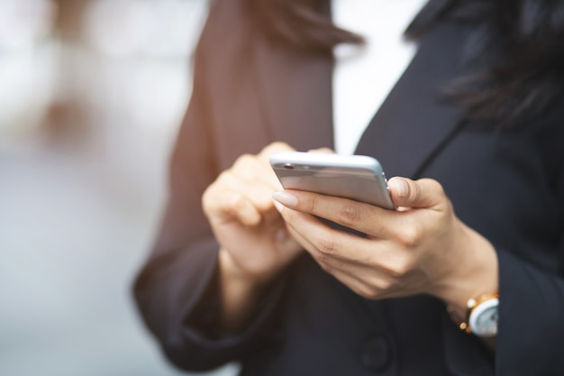 Giovane donna indossa camicia a quadri. chiudere la mano utilizzando sul telefono cellulare durante il riposo sul divano. seduto a guardare il messaggio sul cellulare smart phone durante la pausa rilassarsi.