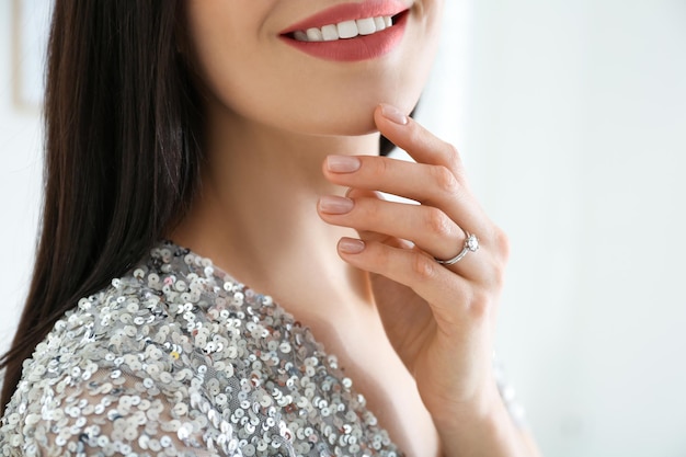 美しい婚約指輪のクローズ アップを身に着けている若い女性