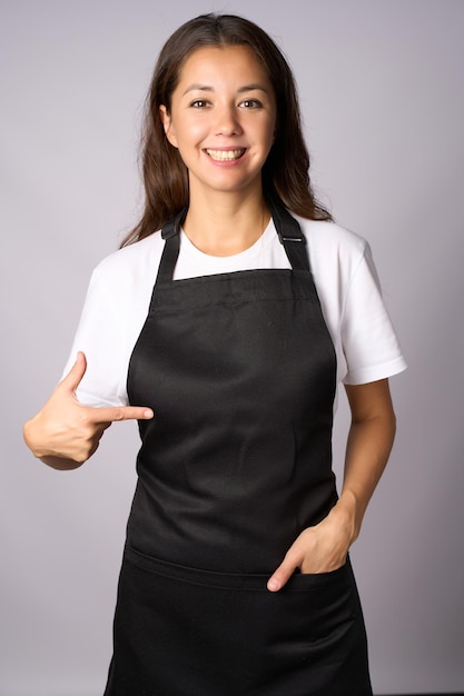 黒い前を着た若い女性が指で前を指さしている