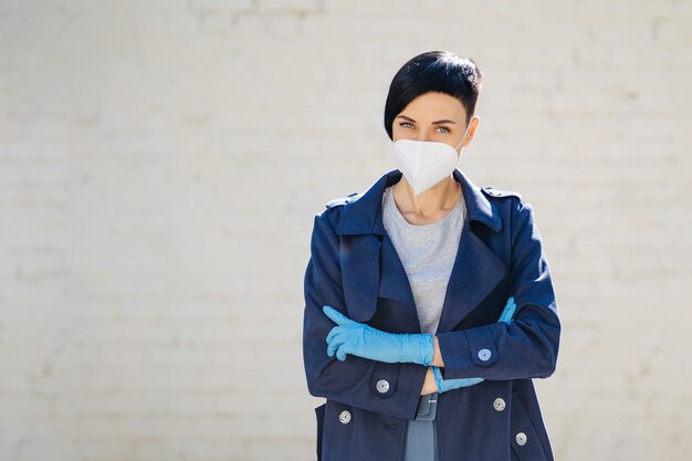 Young woman wearing disposable medical mask and gloves on the street during Covid 19 outbreak. Protection in prevention for coronavirus