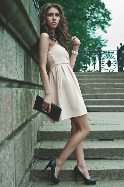  young woman wearing dress and walking on the street