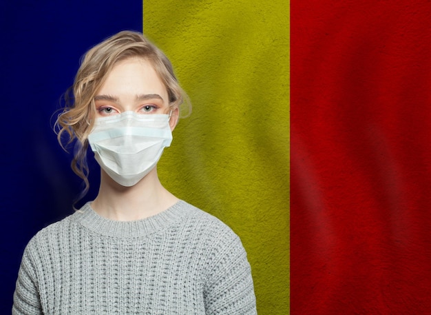 Foto giovane donna che indossa una maschera con la bandiera nazionale rumena concept di protezione contro l'epidemia di influenza e il virus