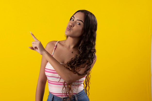 Young woman wearing glasses and a tank top on a yellow background