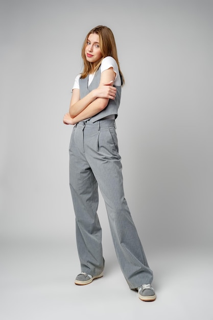灰色のスーツと白いシャツを着た若い女性