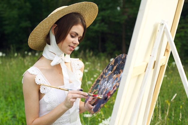 Foto giovane donna con il cappello che tiene la maschera all'aperto