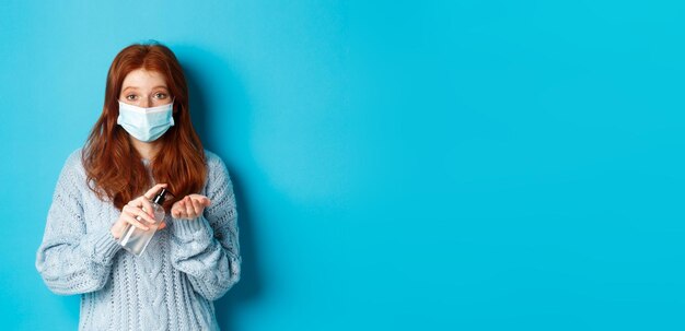 Foto giovane donna con il cappello in piedi sullo sfondo blu