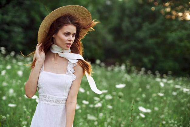 Foto giovane donna con il cappello in piedi contro le piante