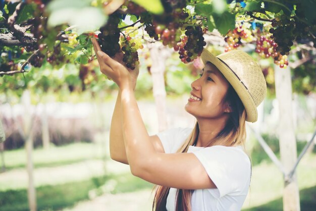 Young woman wearing hat standing against plants