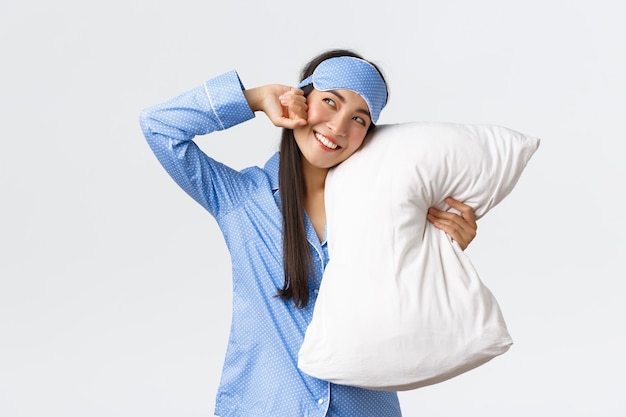 Young woman wearing hat standing against white background