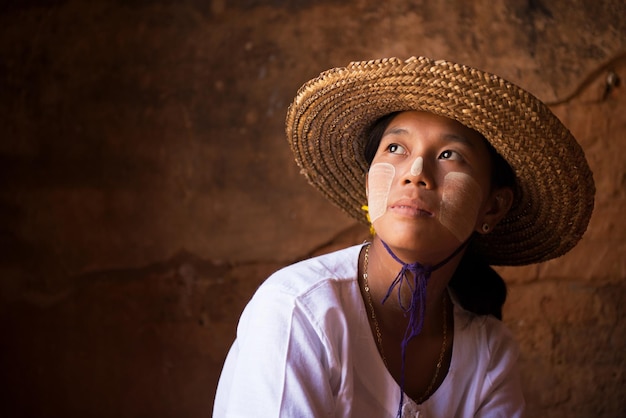 Photo young woman wearing hat with thanaka face paint