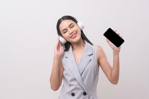 A young woman wearing headphones enjoying with music on white background