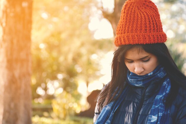 Photo young woman wearing jacket against trees