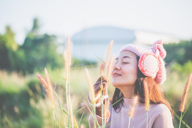 Photo young woman wearing knit hat holding plant