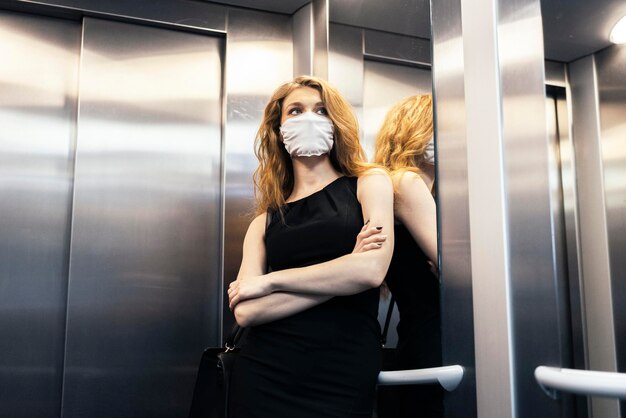 Foto giovane donna con la maschera nell'ascensore