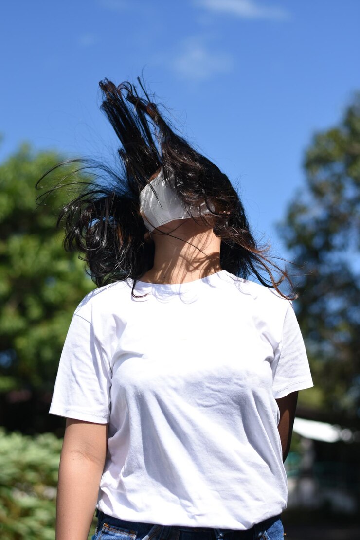 Photo 空に向かって立っているマスクをかぶった若い女性