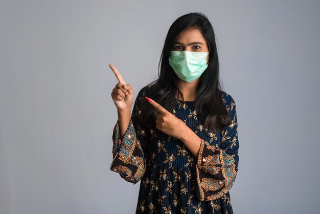 Young woman wearing medical face mask Showing sign. Woman wearing surgical mask for corona virus.