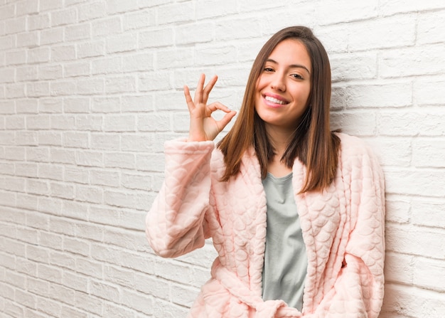 Photo young woman wearing pajama cheerful and confident doing ok gesture