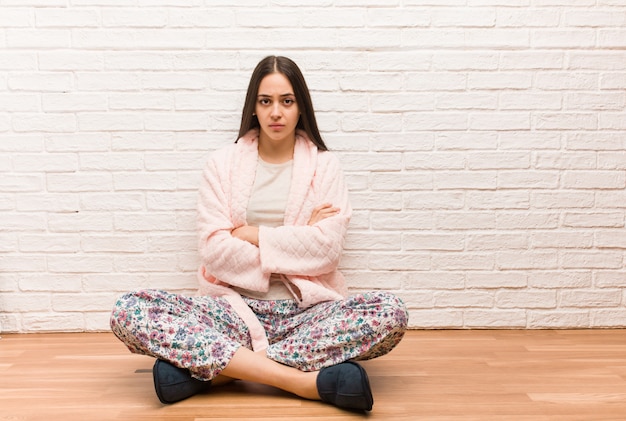 Young woman wearing pajama crossing arms relaxed