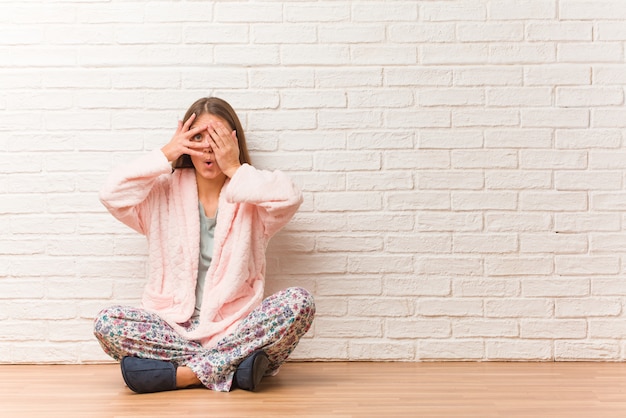 Young woman wearing pajama feels worried and scared