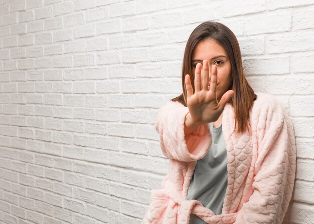 Pigiama da portare della giovane donna che mette la mano davanti