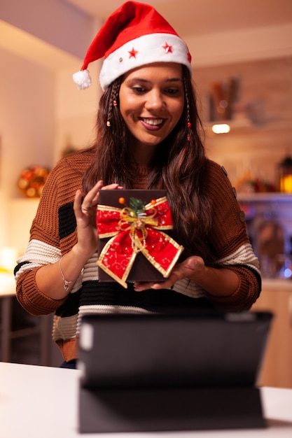 Young woman wearing santa hat using video call technology