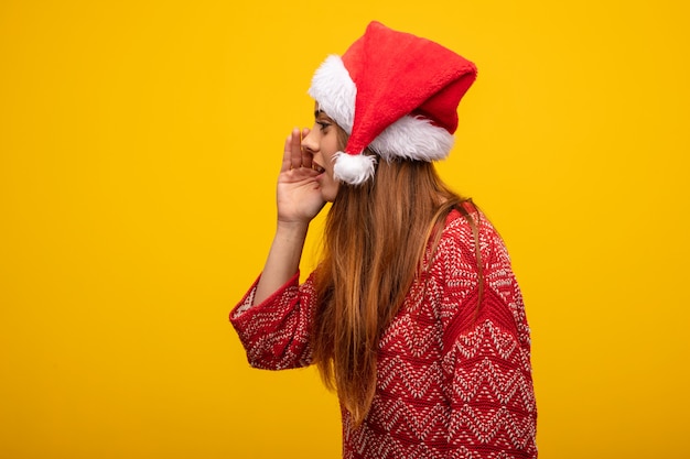 Photo young woman wearing santa hat whispering gossip undertone