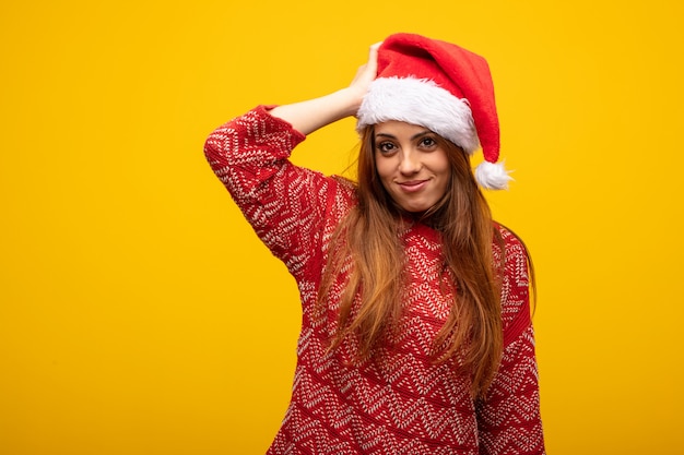 Young woman wearing santa hat worried and overwhelmed
